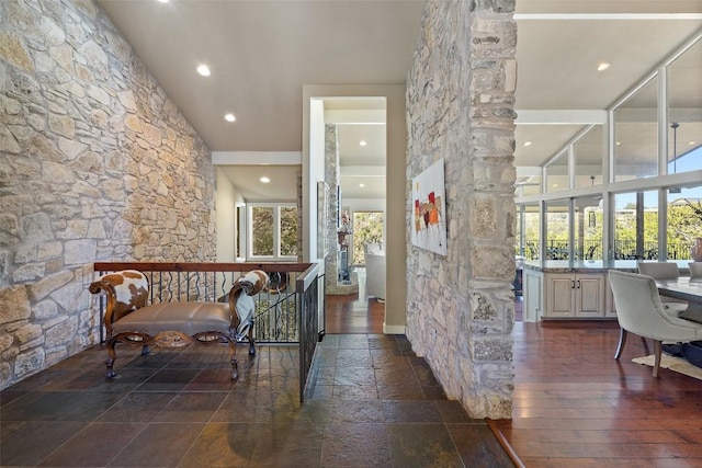 hall with stone tile floors and recessed lighting