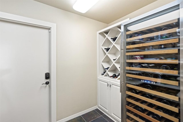 wine cellar featuring dark tile patterned floors and beverage cooler