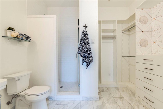 bathroom featuring marble finish floor, a stall shower, and toilet