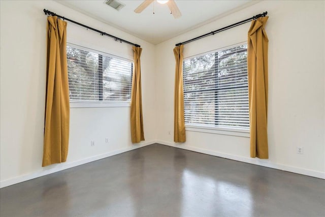 unfurnished room featuring a wealth of natural light, visible vents, concrete floors, and a ceiling fan