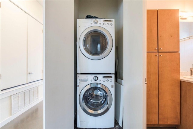 clothes washing area with laundry area and stacked washer and clothes dryer