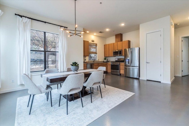 dining area featuring an inviting chandelier, recessed lighting, baseboards, and finished concrete floors