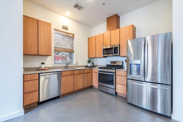 kitchen with visible vents, a sink, concrete floors, appliances with stainless steel finishes, and light countertops