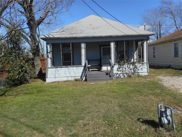 bungalow-style house with a porch, a front yard, and a shingled roof