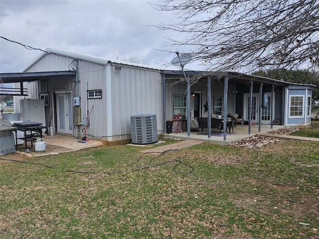 616 S Rockdale St, Lexington, TX 78947 - rear view of house with a lawn, a patio, metal roof, and central AC