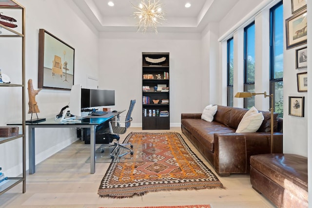 office area featuring wood finished floors, baseboards, a tray ceiling, recessed lighting, and a chandelier