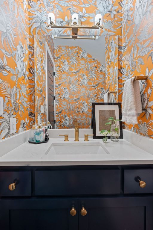 bathroom with vanity and wallpapered walls