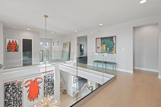 hall featuring recessed lighting, baseboards, a chandelier, and hardwood / wood-style flooring