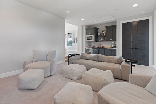 living room featuring baseboards, beverage cooler, light colored carpet, recessed lighting, and a bar