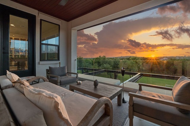 balcony at dusk featuring an outdoor hangout area