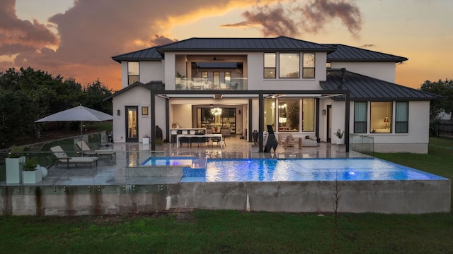 714 Crystal Creek Dr, Austin, TX 78746 - back of property featuring a standing seam roof, a balcony, stucco siding, a metal roof, and an outdoor hangout area