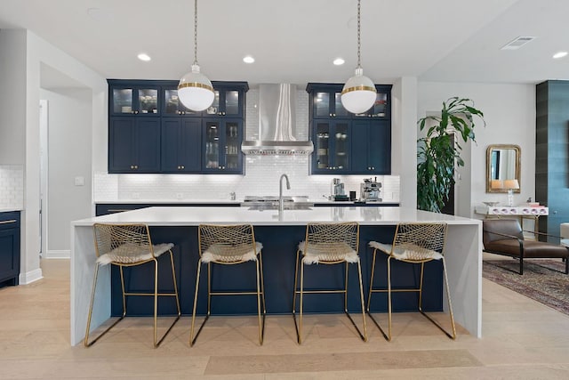 714 Crystal Creek Dr, Austin, TX 78746 - kitchen with wall chimney exhaust hood, blue cabinets, light countertops, and recessed lighting