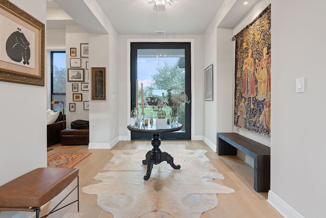 foyer featuring visible vents, light wood-type flooring, and baseboards