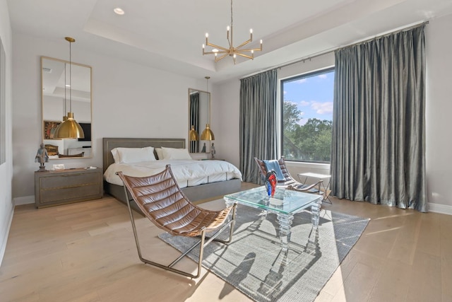 bedroom with wood finished floors, baseboards, a tray ceiling, recessed lighting, and a notable chandelier