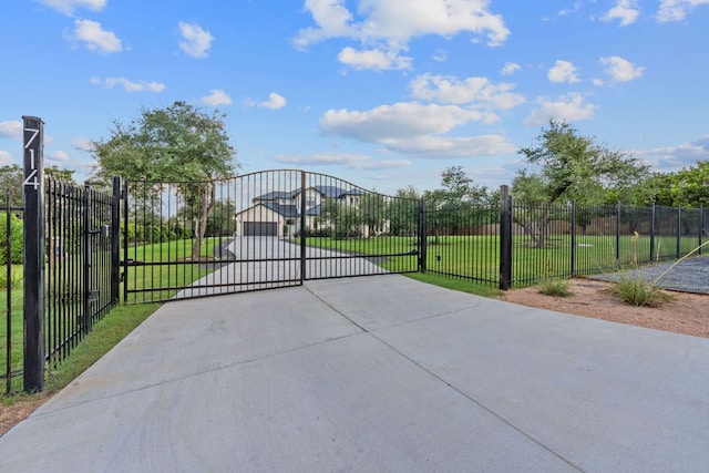 view of gate featuring a lawn and fence