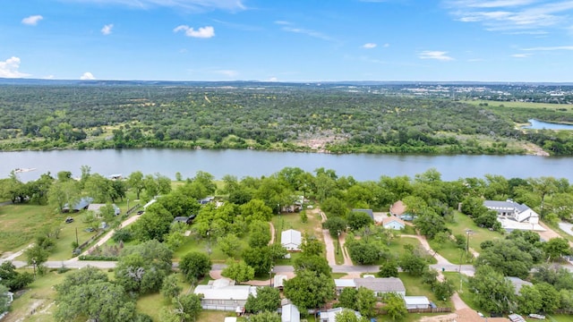 drone / aerial view featuring a water view and a wooded view