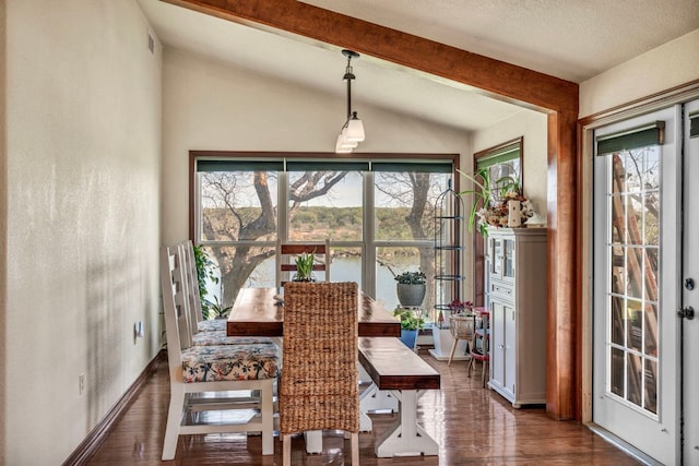 dining room with lofted ceiling with beams, dark wood-style floors, baseboards, and visible vents