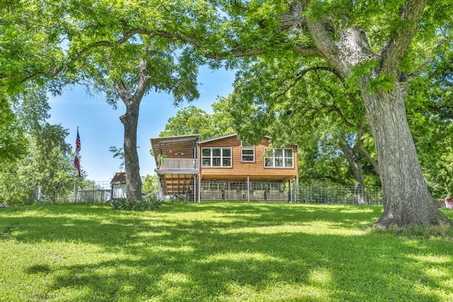 rear view of property with a wooden deck, a lawn, and fence