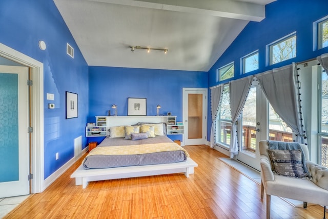 331 Grandview Dr, Horseshoe Bay, TX 78657 - bedroom featuring access to exterior, wood-type flooring, beam ceiling, and high vaulted ceiling