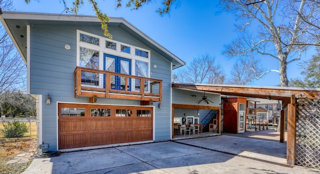 view of front facade featuring a garage, a balcony, concrete driveway, and ceiling fan