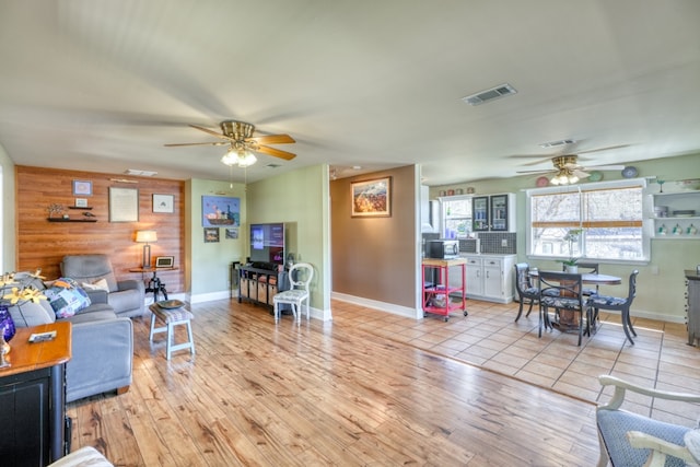 331 Grandview Dr, Horseshoe Bay, TX 78657 - living area with a ceiling fan, baseboards, light wood-style floors, and wood walls