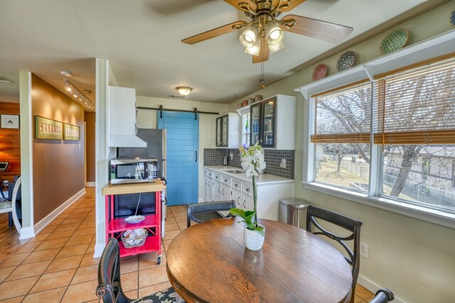 331 Grandview Dr, Horseshoe Bay, TX 78657 - dining space with a barn door, light tile patterned floors, ceiling fan, and baseboards