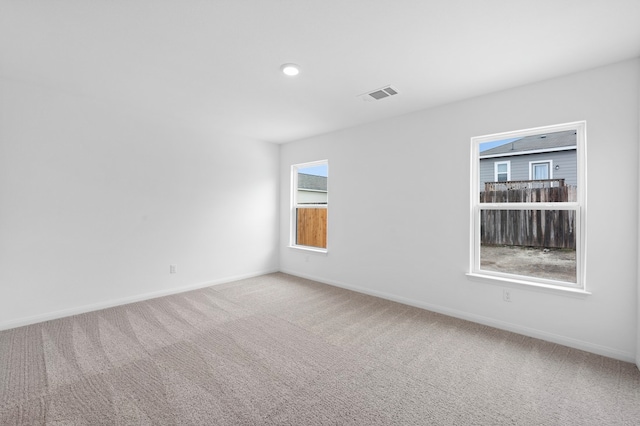 empty room with visible vents, baseboards, and carpet