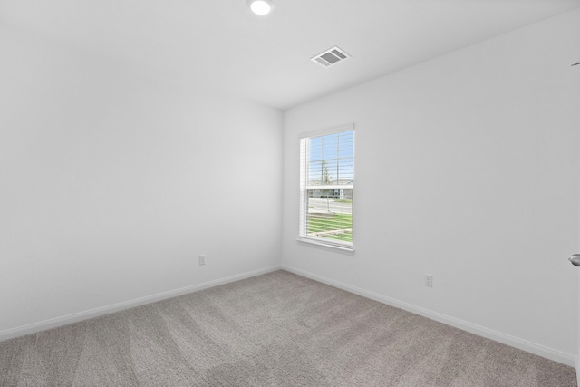 carpeted empty room featuring visible vents and baseboards