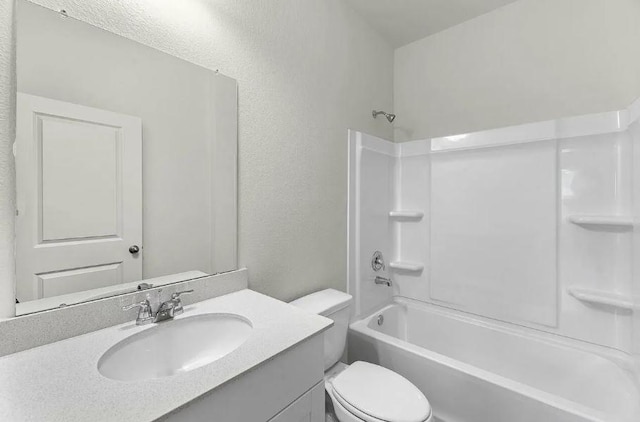 full bathroom with shower / bathing tub combination, toilet, vanity, and a textured wall