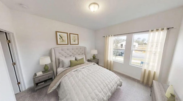 bedroom featuring light colored carpet and baseboards