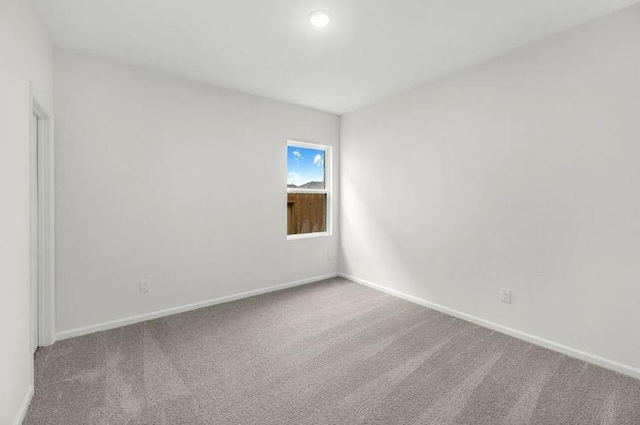 carpeted empty room with baseboards