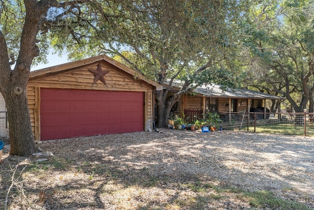 view of front of house with gravel driveway, a garage, and covered porch