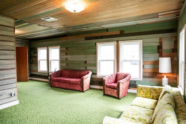 carpeted living room with wooden ceiling and wood walls