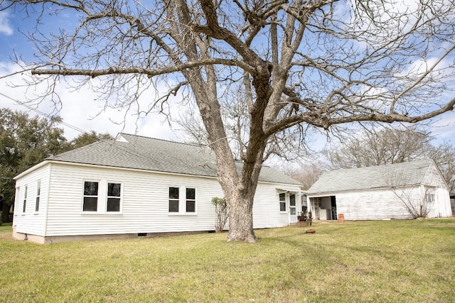 back of property featuring crawl space, a yard, and a shingled roof