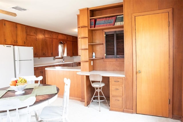 kitchen featuring open shelves, visible vents, brown cabinets, and light countertops