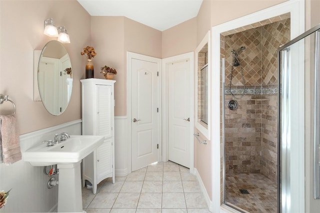 bathroom featuring a sink, a stall shower, and tile patterned flooring