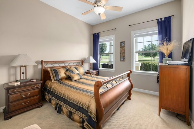 bedroom with light carpet, ceiling fan, and baseboards