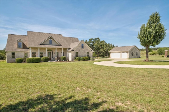 view of front facade with an outdoor structure, a front lawn, and a detached garage