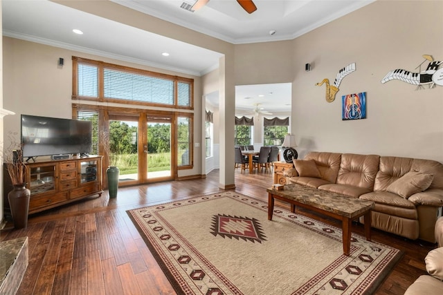 living room featuring ceiling fan, a high ceiling, dark wood-style flooring, and ornamental molding