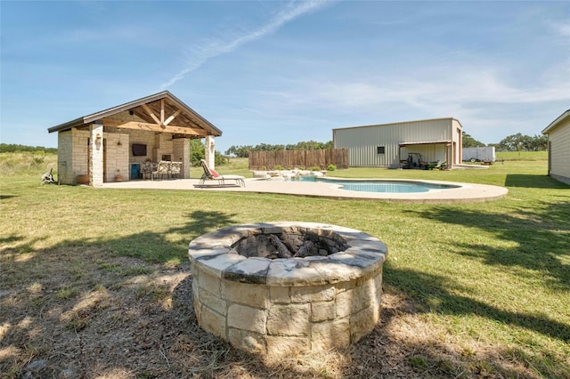 view of yard featuring an outdoor fire pit, fence, an outdoor structure, an outdoor pool, and a patio area