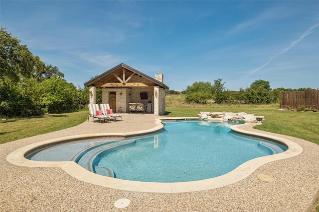 pool with an exterior structure, a yard, a patio, and an outbuilding