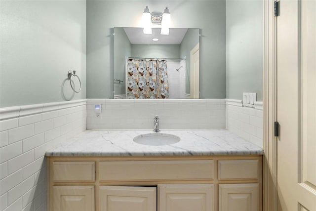 bathroom with tile walls, a wainscoted wall, vanity, and a shower with shower curtain