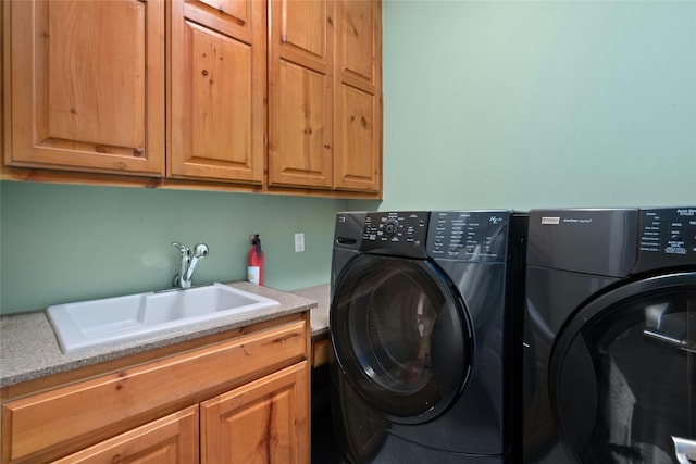 laundry area featuring a sink, cabinet space, and washer and clothes dryer