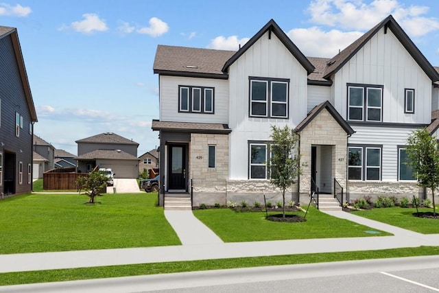 503 Emory Crossing Blvd, Hutto, TX 78634 - view of front of house with stone siding, board and batten siding, a front lawn, and roof with shingles