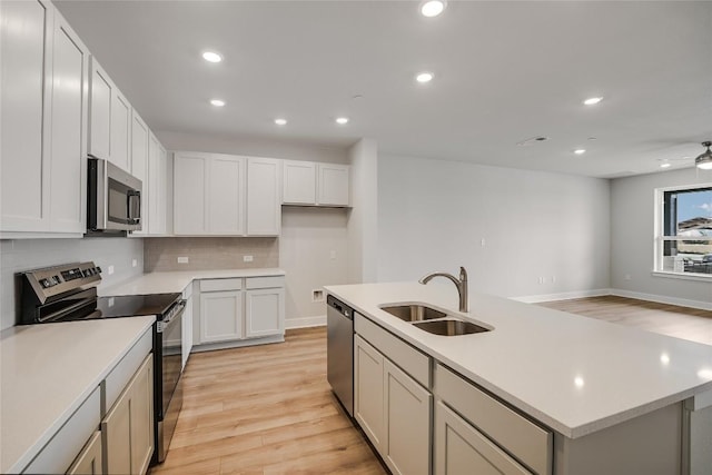 503 Emory Crossing Blvd, Hutto, TX 78634 - kitchen featuring stainless steel appliances, a sink, light wood-type flooring, backsplash, and recessed lighting