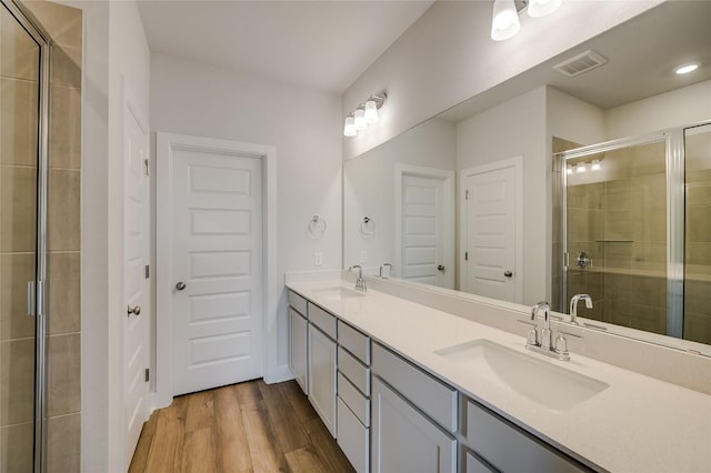 503 Emory Crossing Blvd, Hutto, TX 78634 - bathroom with a shower stall, wood finished floors, and double vanity
