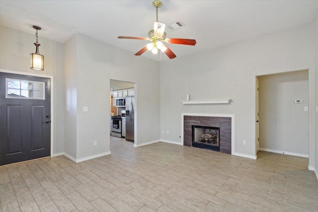 entryway with a fireplace, wood finished floors, baseboards, and a ceiling fan