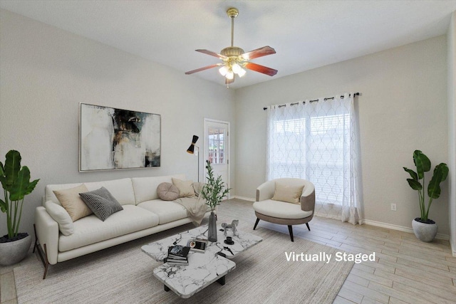 living area with baseboards, ceiling fan, and wood finished floors