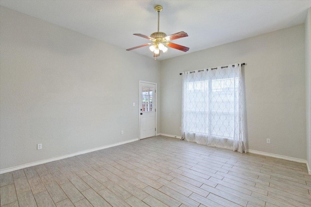 spare room with light wood finished floors, baseboards, and ceiling fan