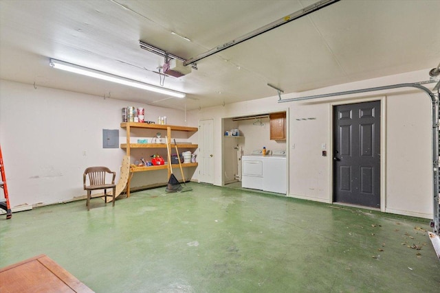 garage with electric panel, washing machine and dryer, and a garage door opener